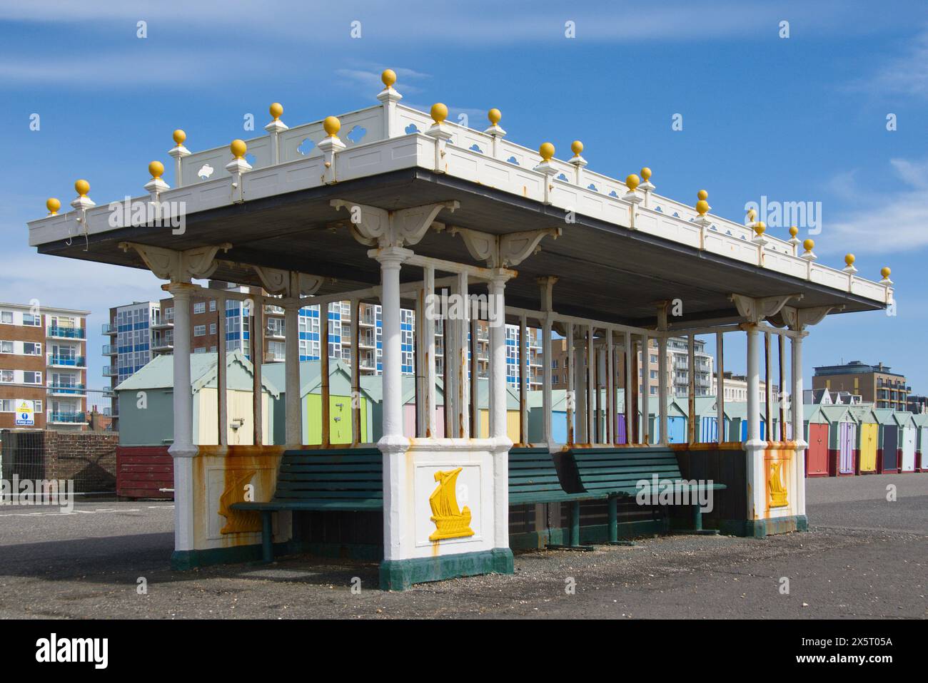 Riparo sul lungomare a Brighton e Hove nell'East Sussex, Inghilterra. Con capanne sulla spiaggia dietro. Foto Stock