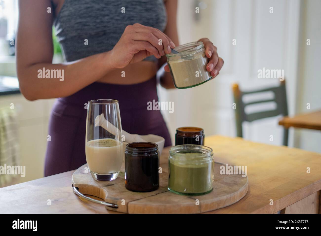 Donna che prepara bevande salutari a casa Foto Stock