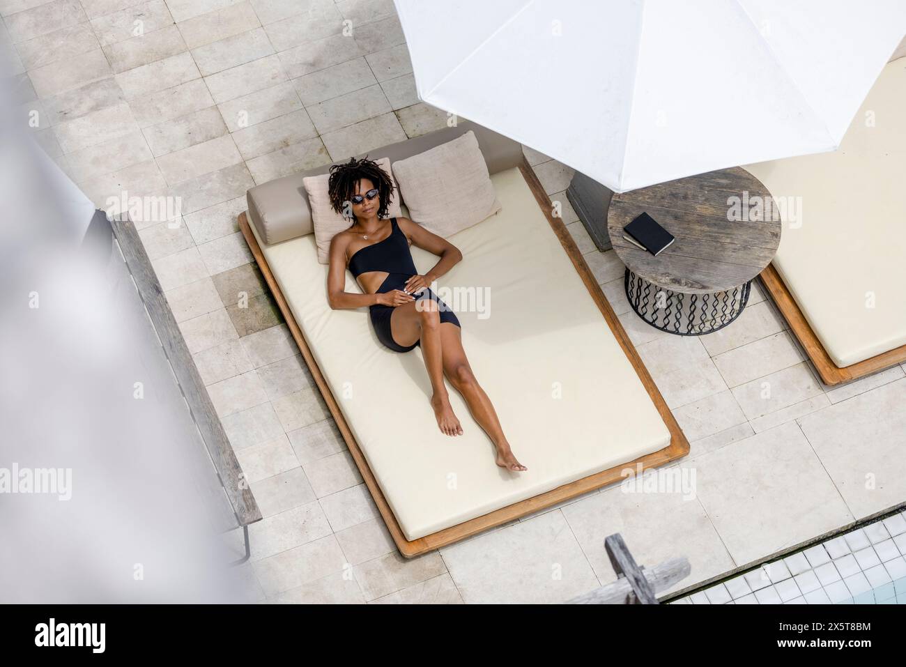 Vista dall'alto di una donna che si rilassa a bordo piscina Foto Stock