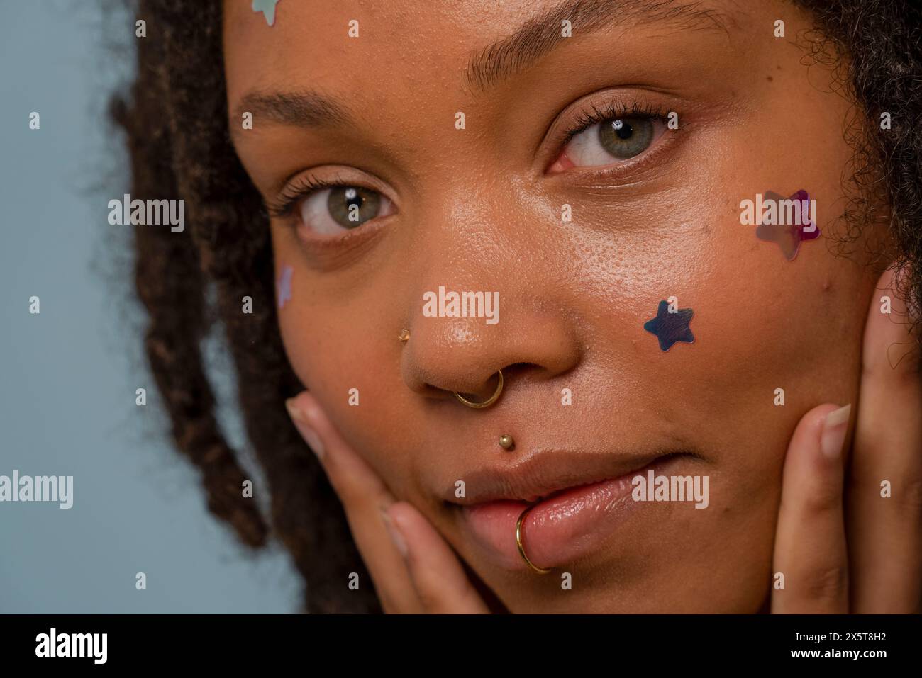 Ritratto di una giovane donna che indossa adesivi stellari sul viso Foto Stock