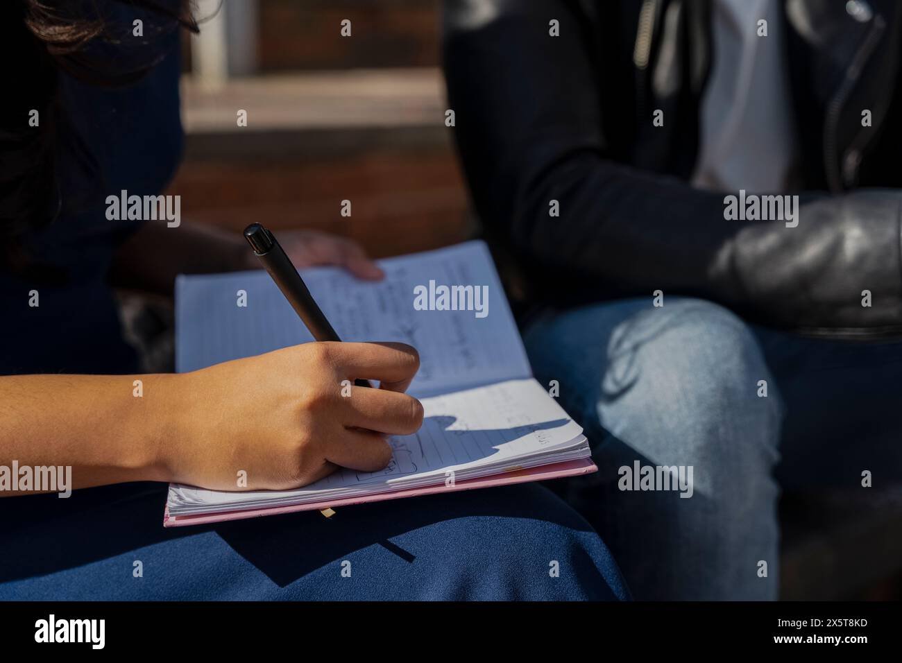 Primo piano di studenti che scrivono su un notebook Foto Stock