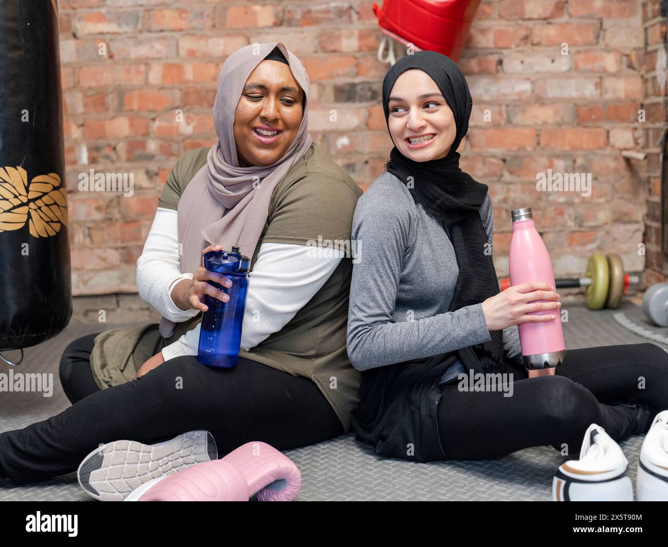 Due donne sorridenti che riposano in palestra Foto Stock