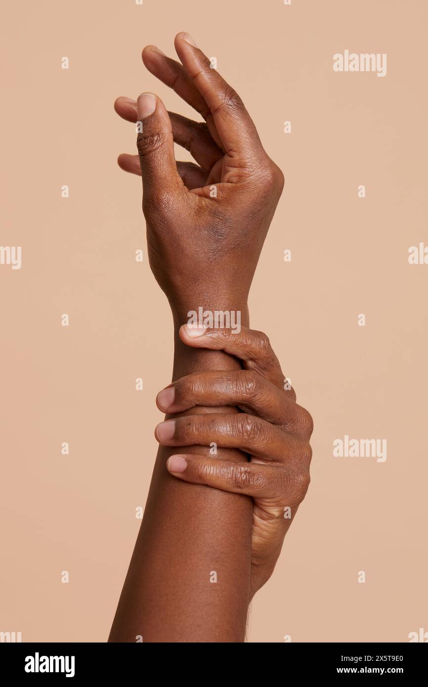 Mani di donna su sfondo beige Foto Stock