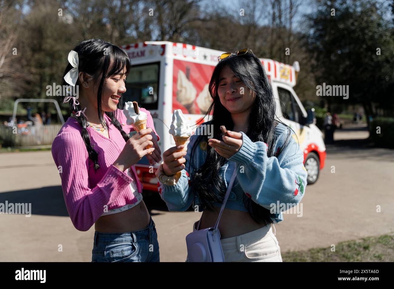 Giovani donne che mangiano gelato nel parco Foto Stock