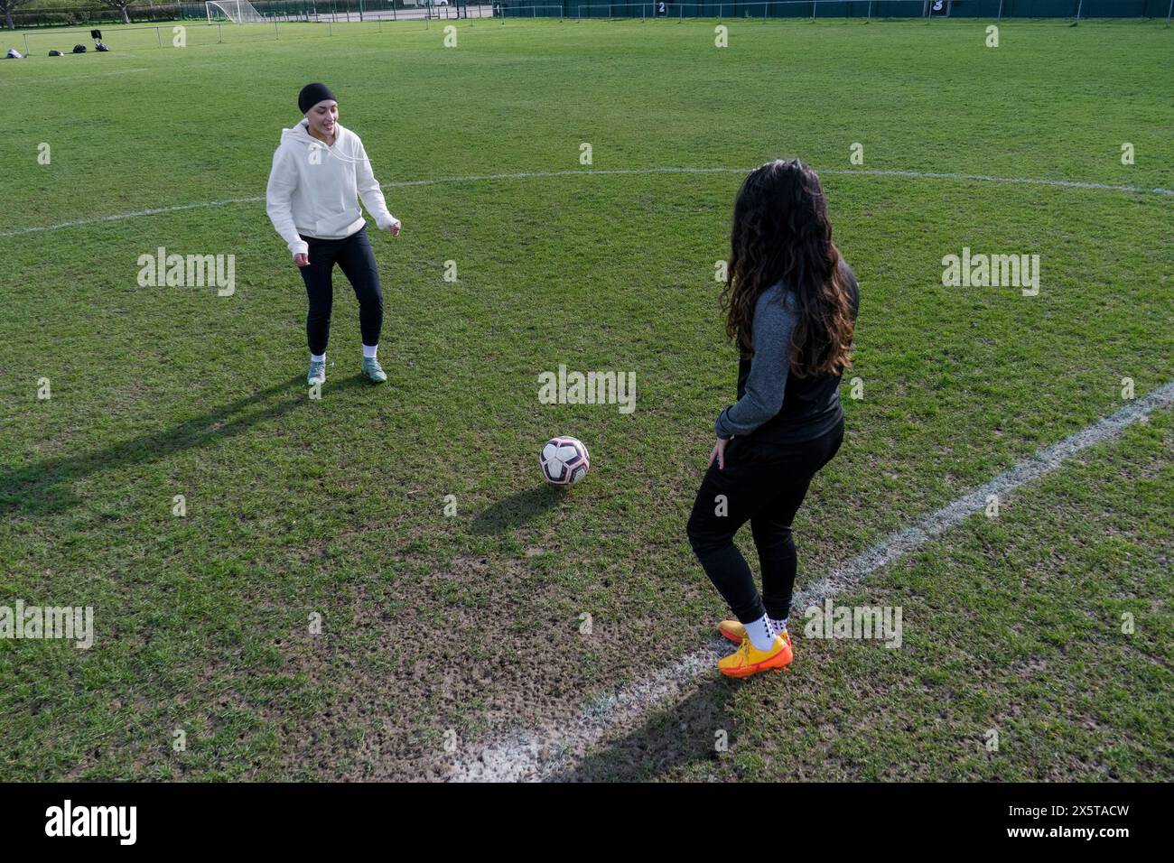 Giovani donne che giocano a calcio all'aperto Foto Stock