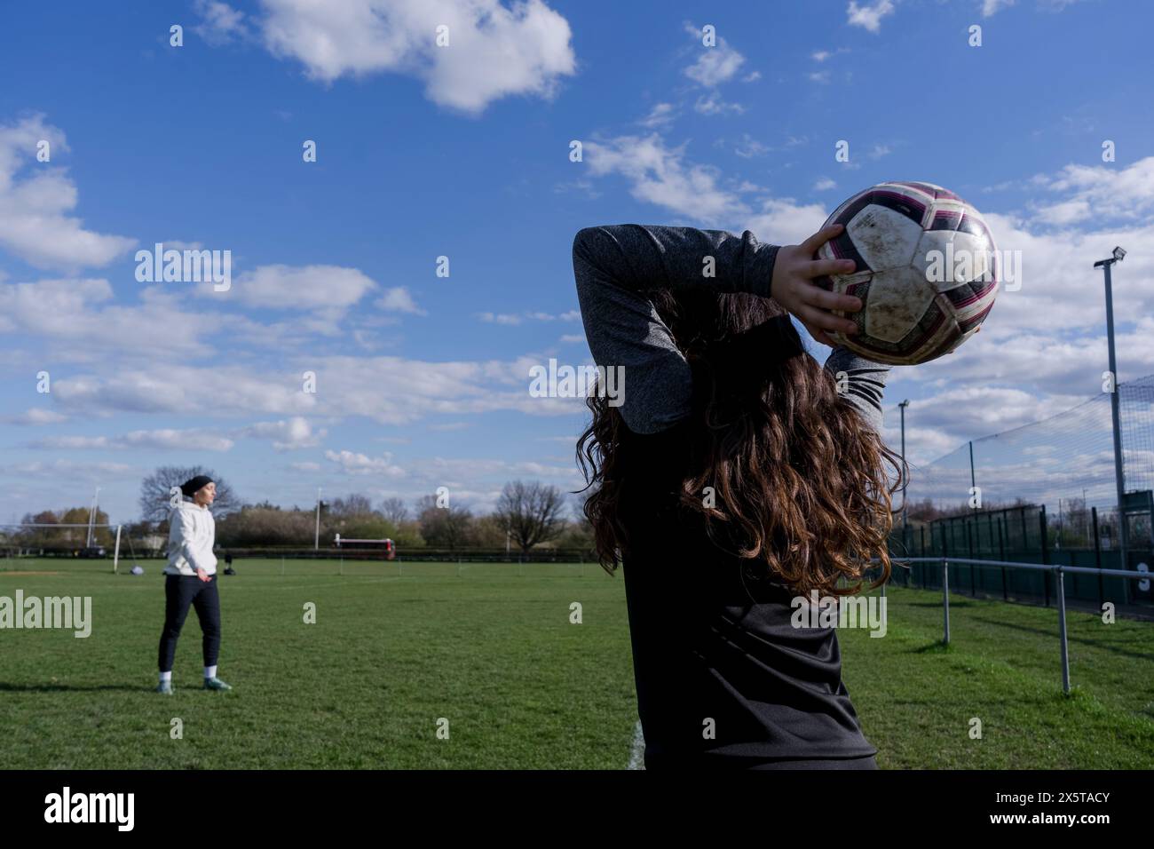 Giovani donne che giocano a calcio all'aperto Foto Stock