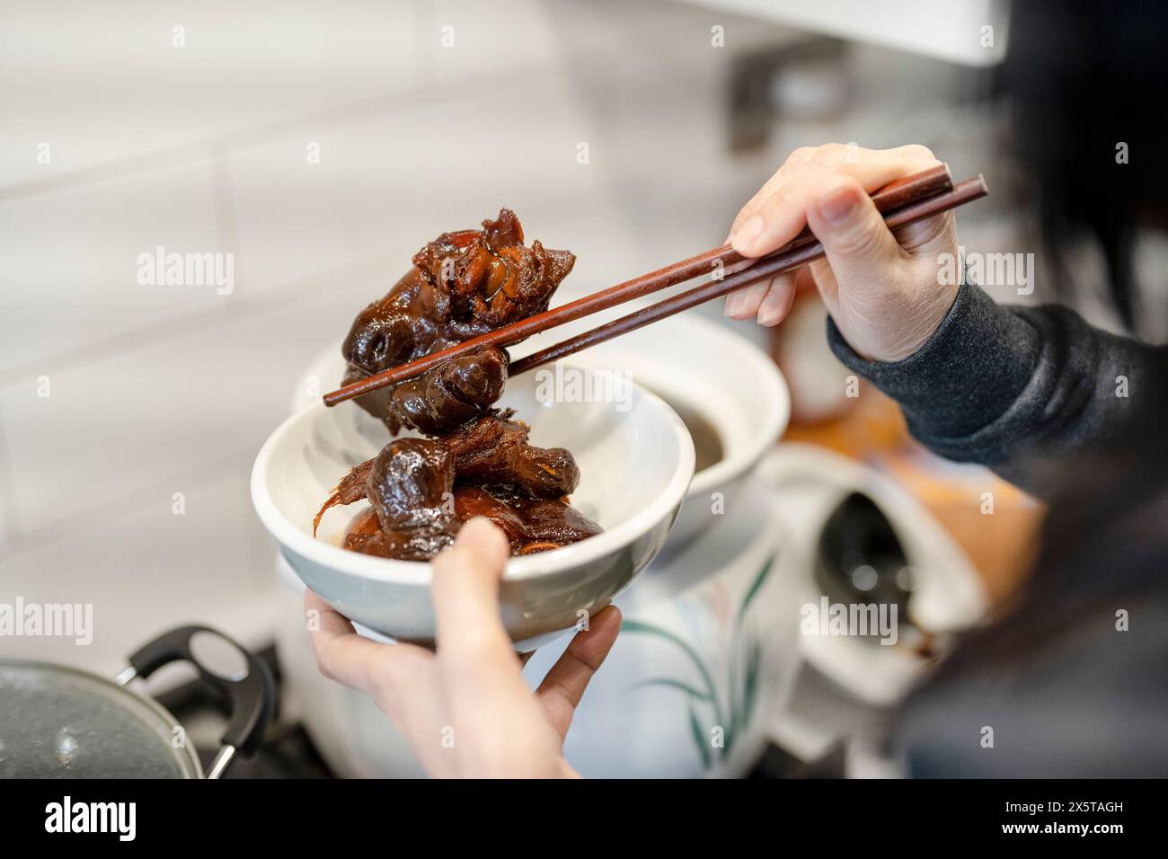 Donna che serve a casa una noce di maiale con aceto di zenzero Foto Stock