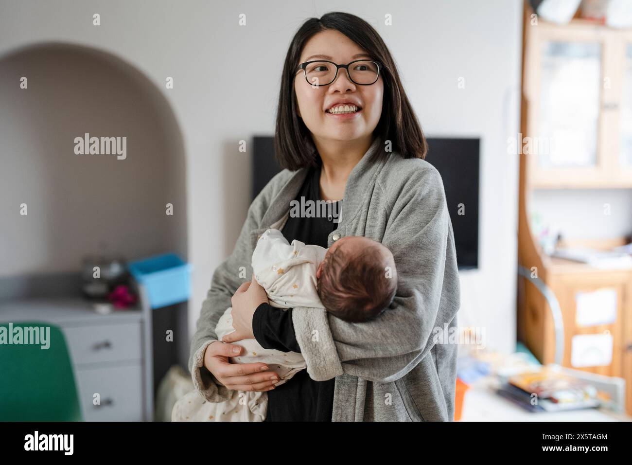 Madre che tiene in braccio il neonato (0-1 mesi) Foto Stock