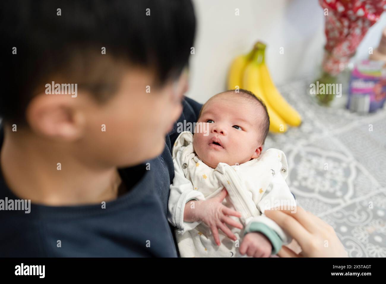 Padre che tiene in braccio una figlia (0-1) Foto Stock