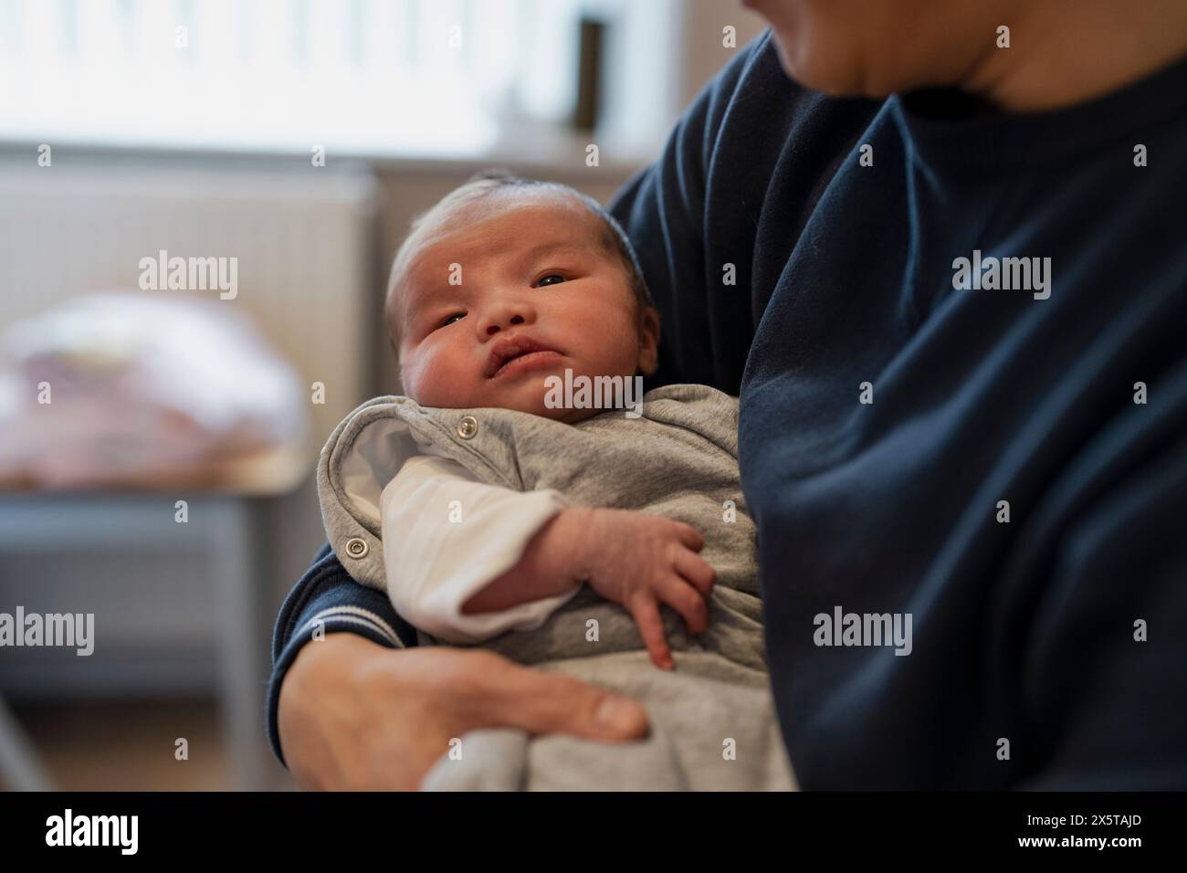 Padre che tiene in braccio una figlia (0-1 mesi) Foto Stock