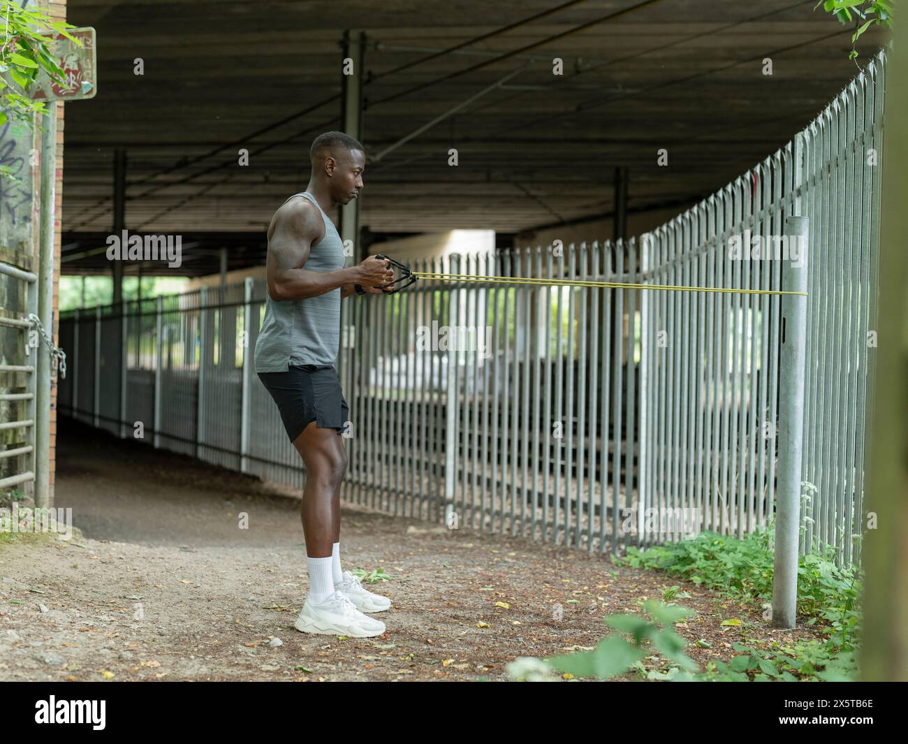 Uomo che si allena con la fascia di resistenza all'aperto Foto Stock