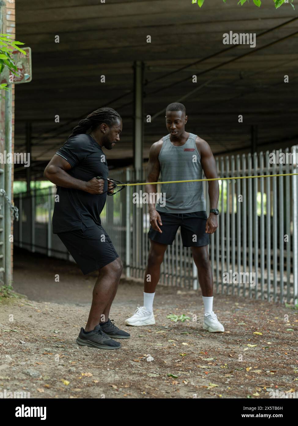 Due uomini che si allenano con la banda di resistenza all'aperto Foto Stock