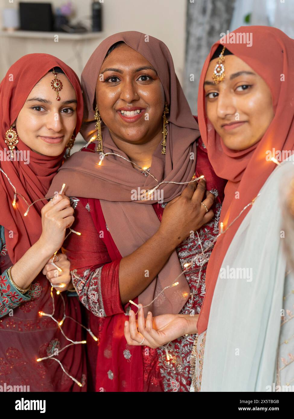 Ritratto di donne sorridenti che reggono una serie di luci Foto Stock