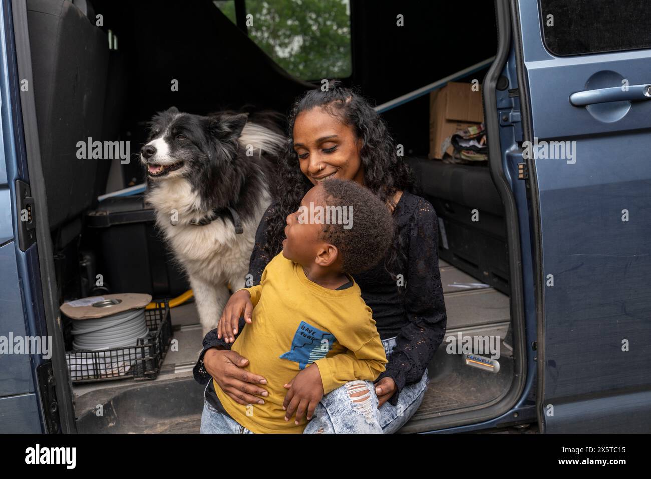 Madre con figlio e cane nel furgone che si prepara per il viaggio Foto Stock