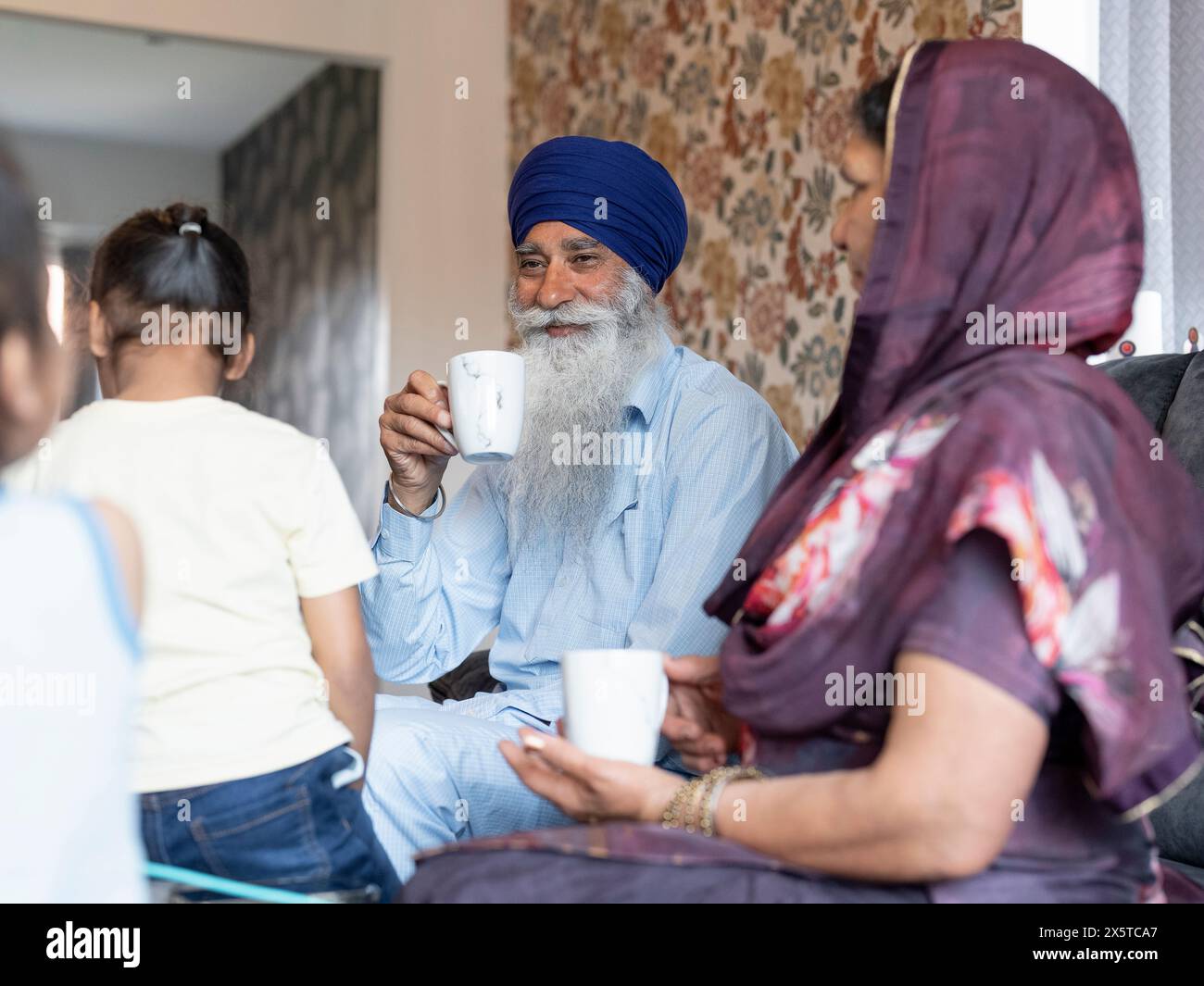 Nonni e nipoti (6-7) che si rilassano a casa Foto Stock