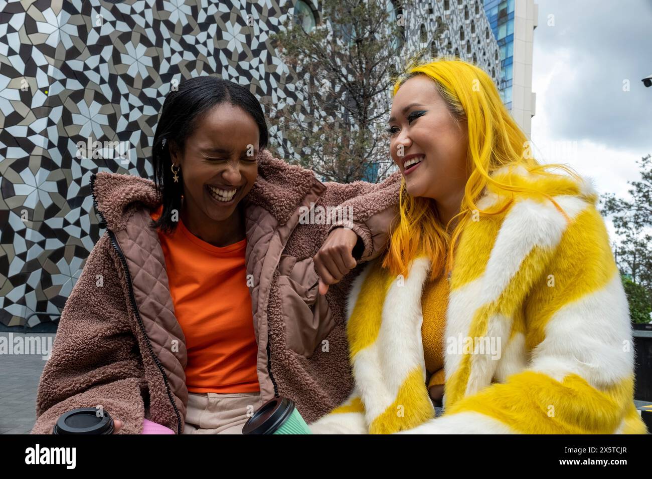 Giovani amiche che ridono all'aperto Foto Stock