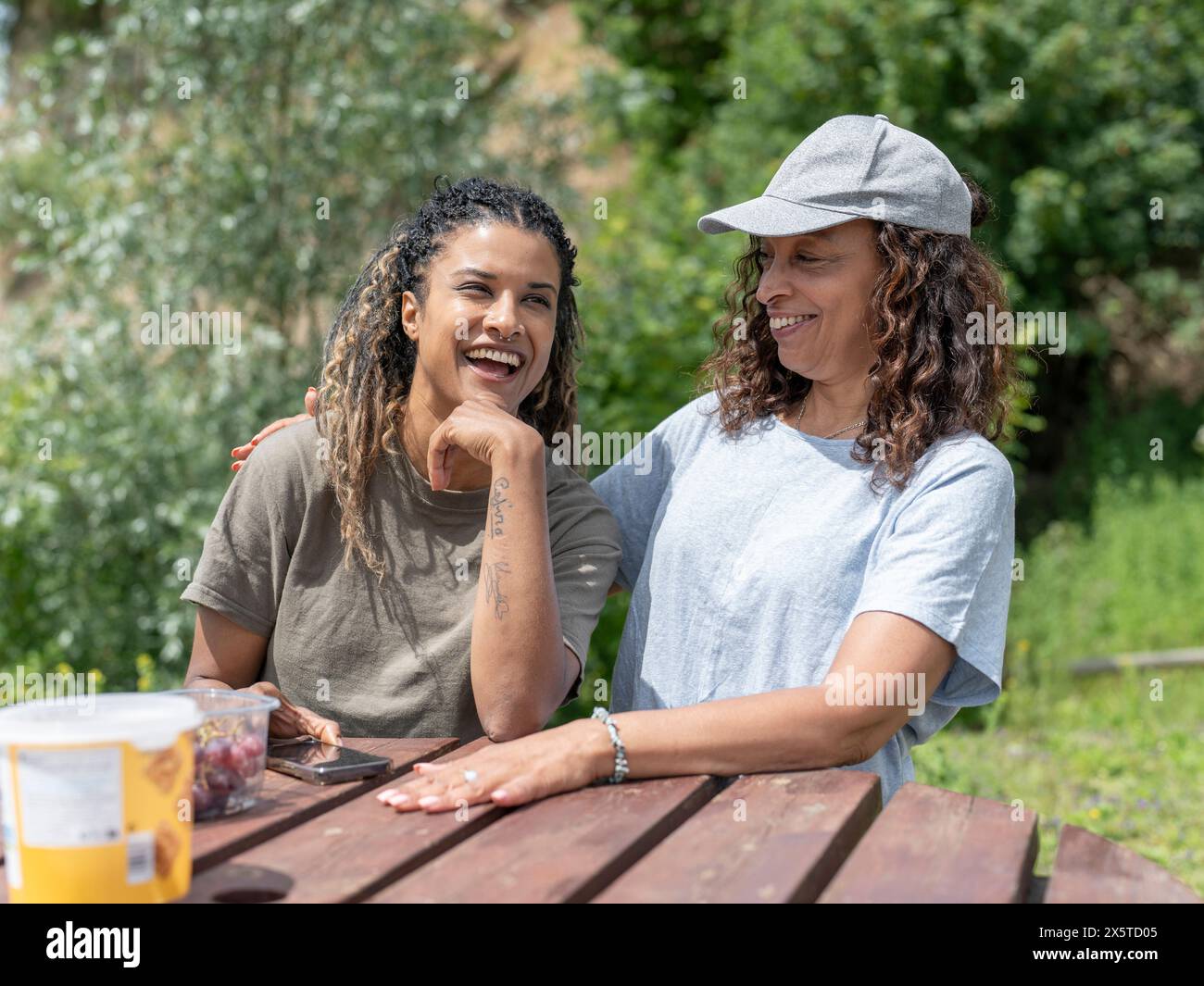 Amici che ridono durante il picnic Foto Stock
