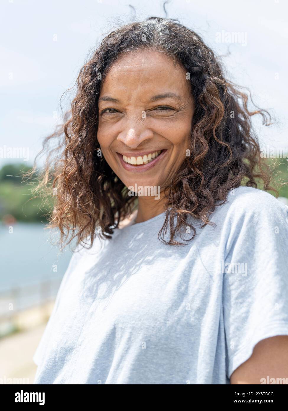 Ritratto di donna sorridente al lago Foto Stock