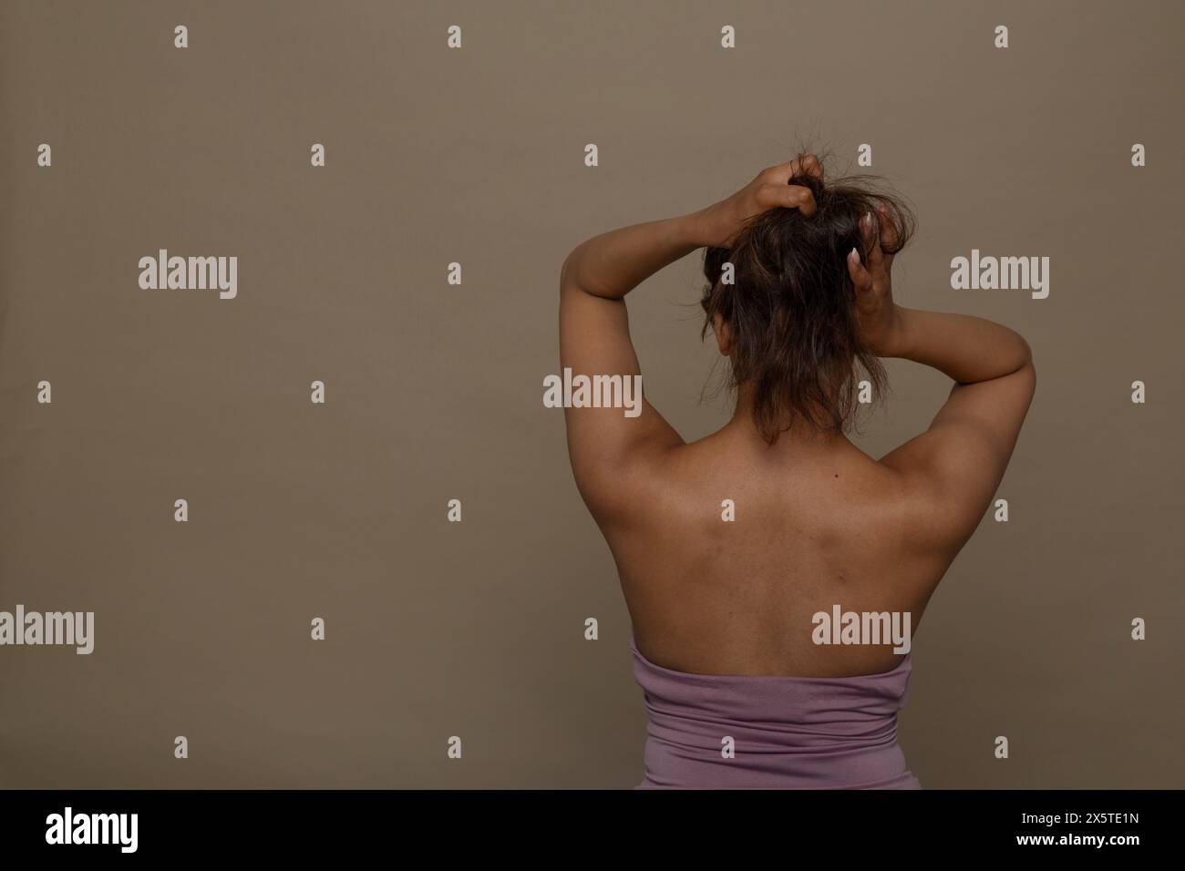 Vista posteriore della donna con le mani nei capelli Foto Stock