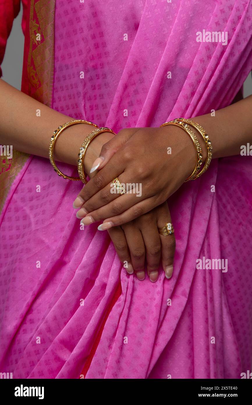 Sezione intermedia di donna che indossa sari e gioielli in oro Foto Stock
