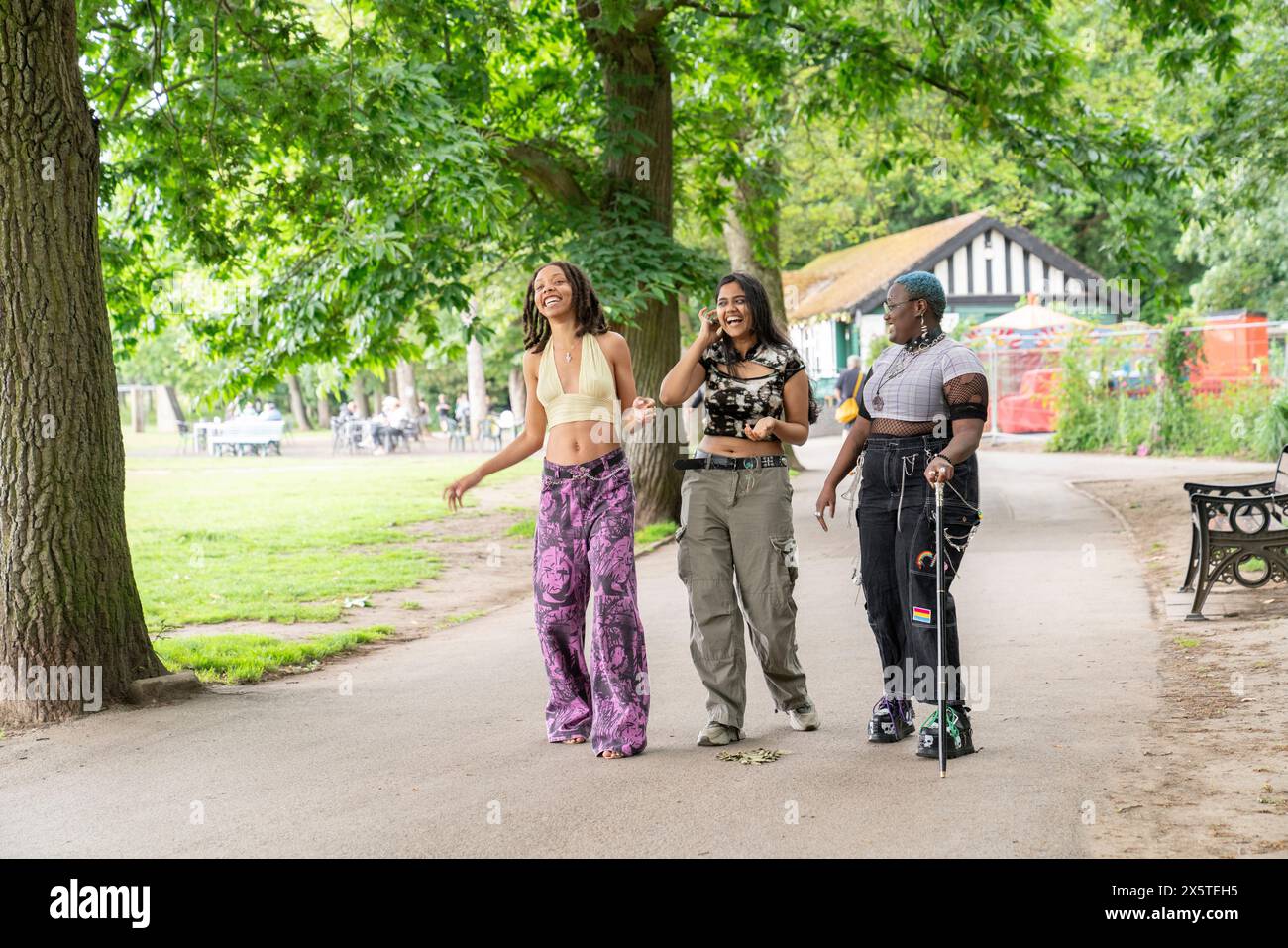 Tre amici che ridono mentre camminano nel parco Foto Stock