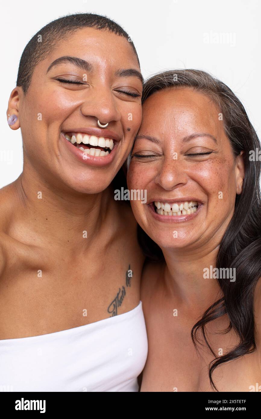 Ritratto in studio di donne che ridono con gli occhi chiusi Foto Stock