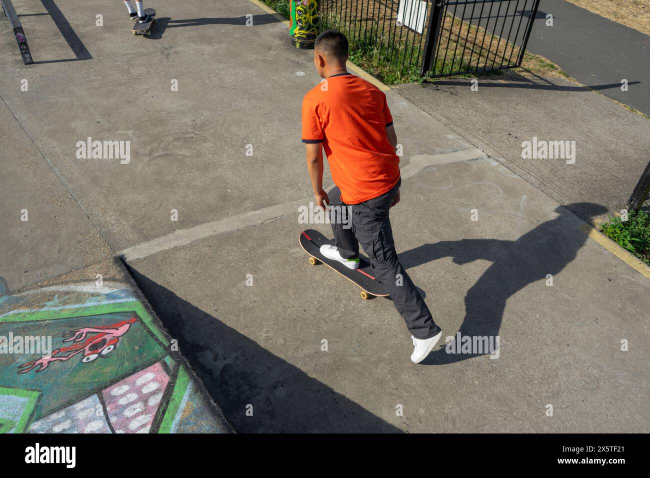 Giovane uomo skateboarding in skate park Foto Stock