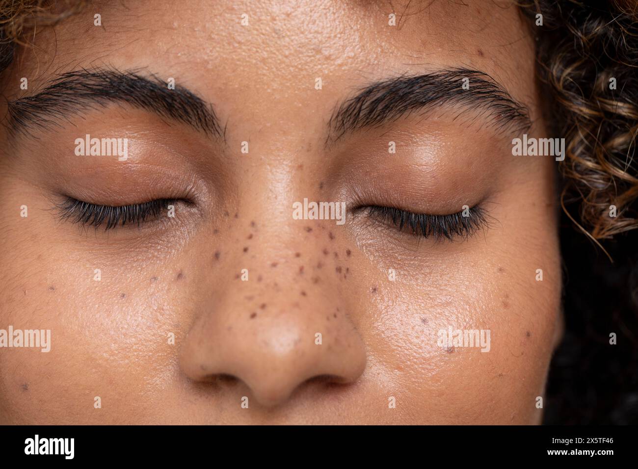 Donna con gli occhi chiusi e lentiggini sul viso Foto Stock