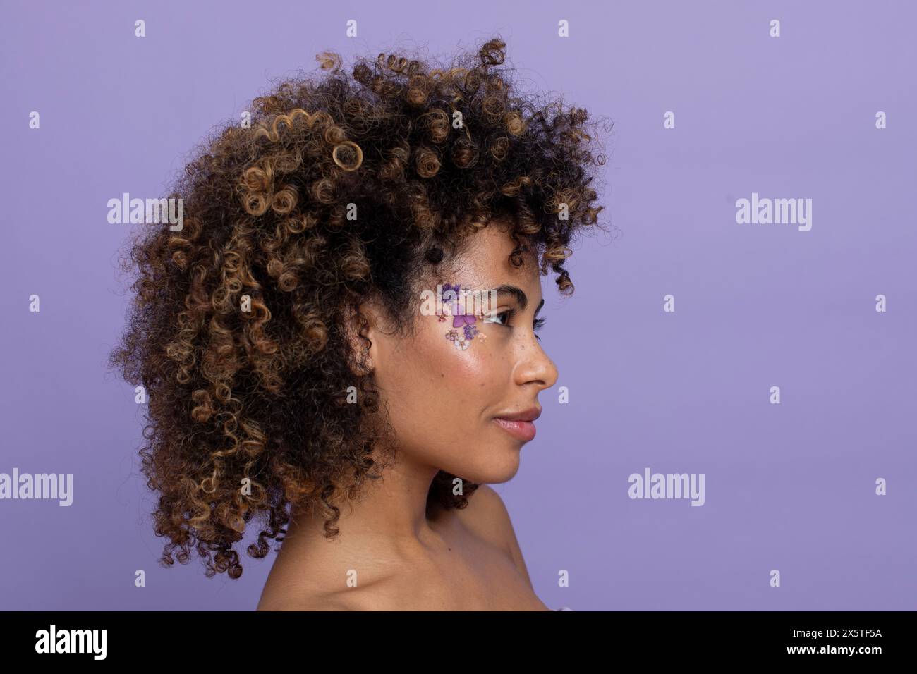Donna bruna con fiori in faccia Foto Stock