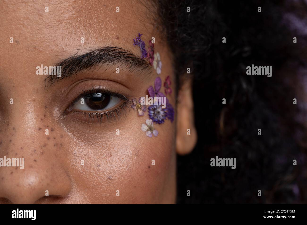 Primo piano di fiori sulla faccia delle donne Foto Stock