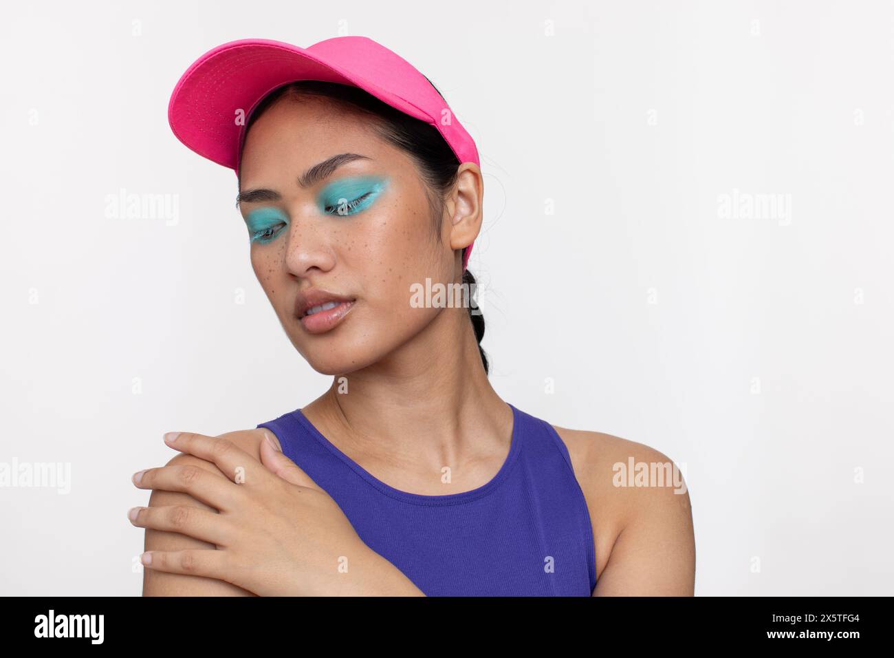 Ritratto di donna che indossa il trucco blu e la visiera parasole Foto Stock