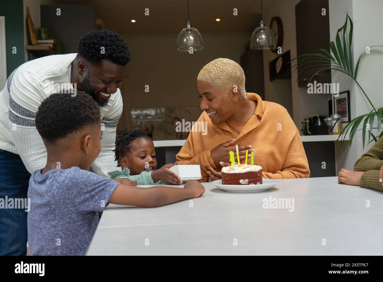 Famiglia con bambini (2-3, 6-7, 12-13) che festeggia il compleanno a casa Foto Stock