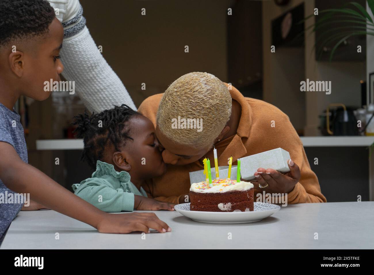 Famiglia con bambini (2-3, 6-7) che festeggia il compleanno a casa Foto Stock