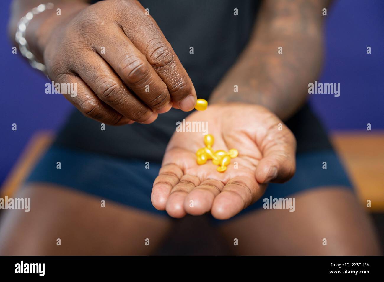 Primo piano di un uomo che tiene in mano le capsule gialle Foto Stock