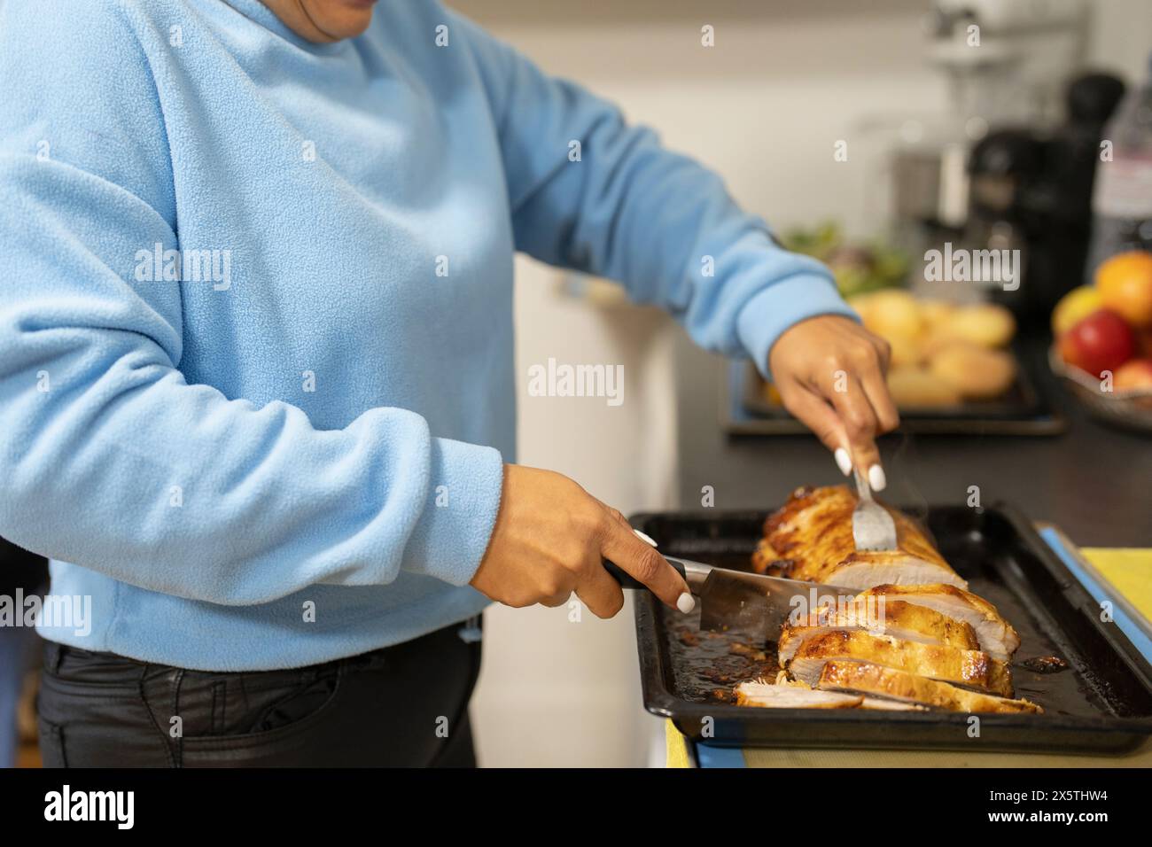 Sezione centrale della donna che affetta carne cotta Foto Stock