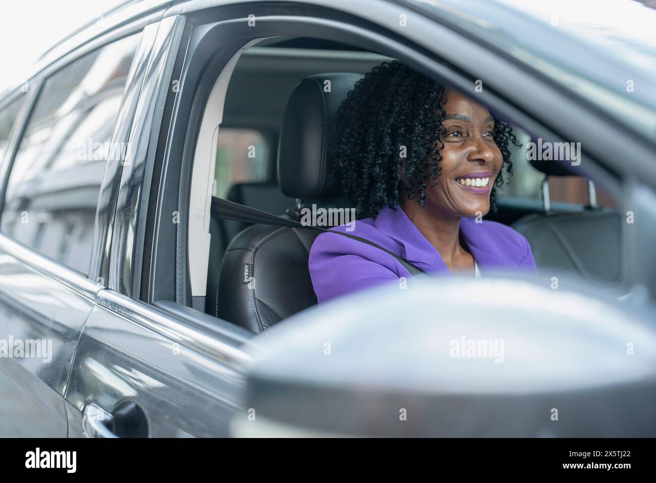 Donna sorridente auto pilotaggio Foto Stock