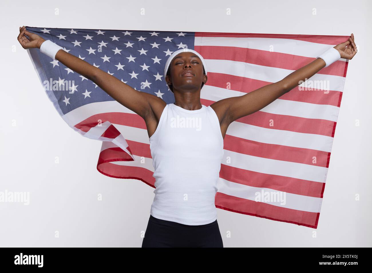 Ritratto in studio di una donna atletica in abbigliamento sportivo con bandiera americana Foto Stock