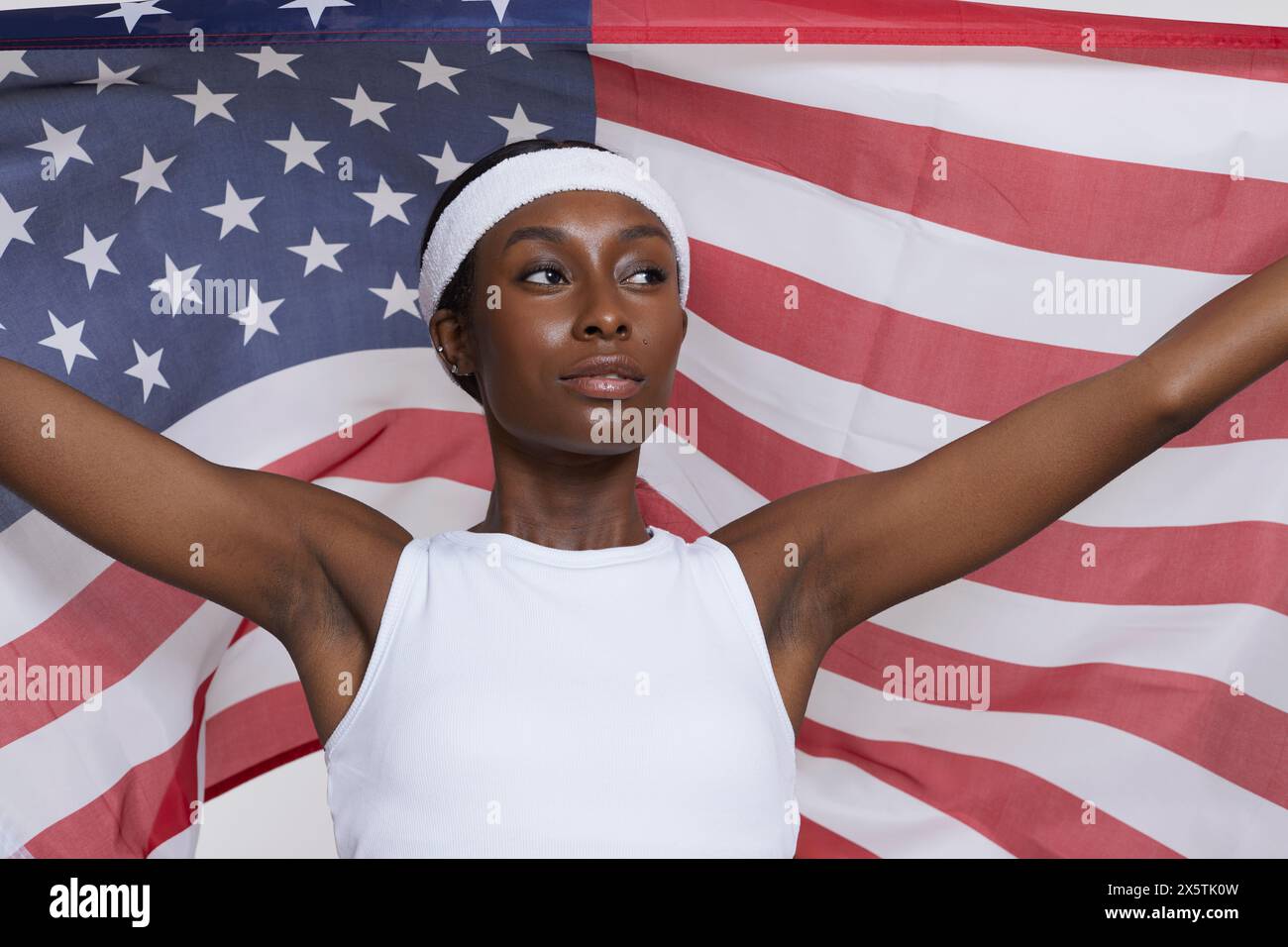 Ritratto in studio di una donna atletica in abbigliamento sportivo con bandiera americana Foto Stock