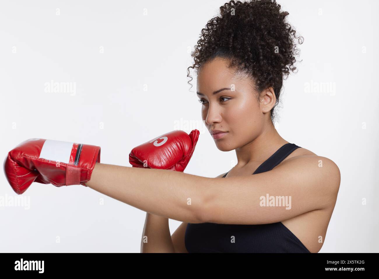 Ritratto in studio di una donna atletica con guanti da boxe Foto Stock