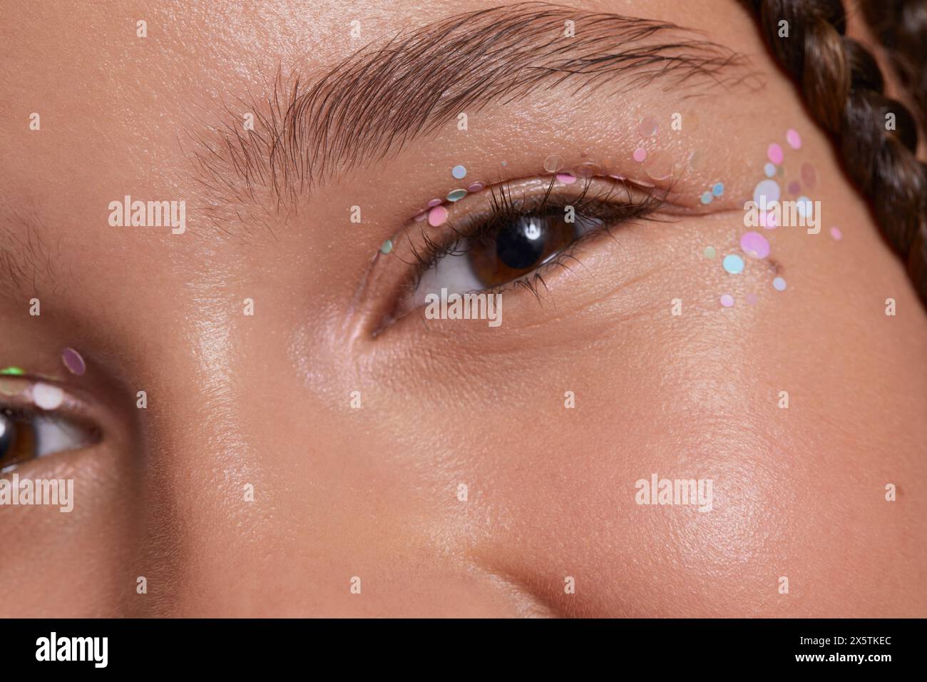 Primo piano di una ragazza sorridente con adesivi decorativi sul viso Foto Stock
