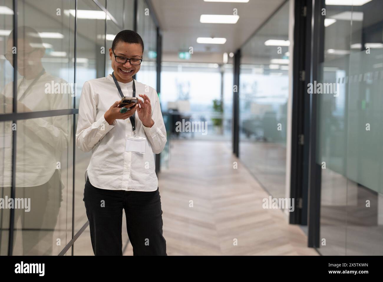 Lavoratore non binario in ufficio in corridoio Foto Stock