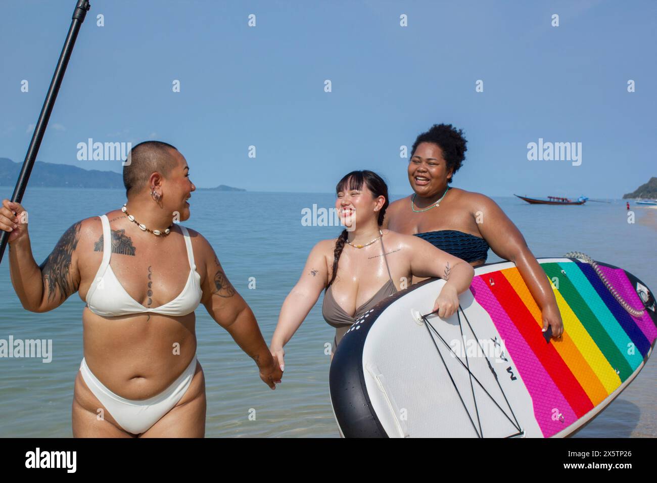 Gruppo di donne allegre che camminano con il paddleboard Foto Stock