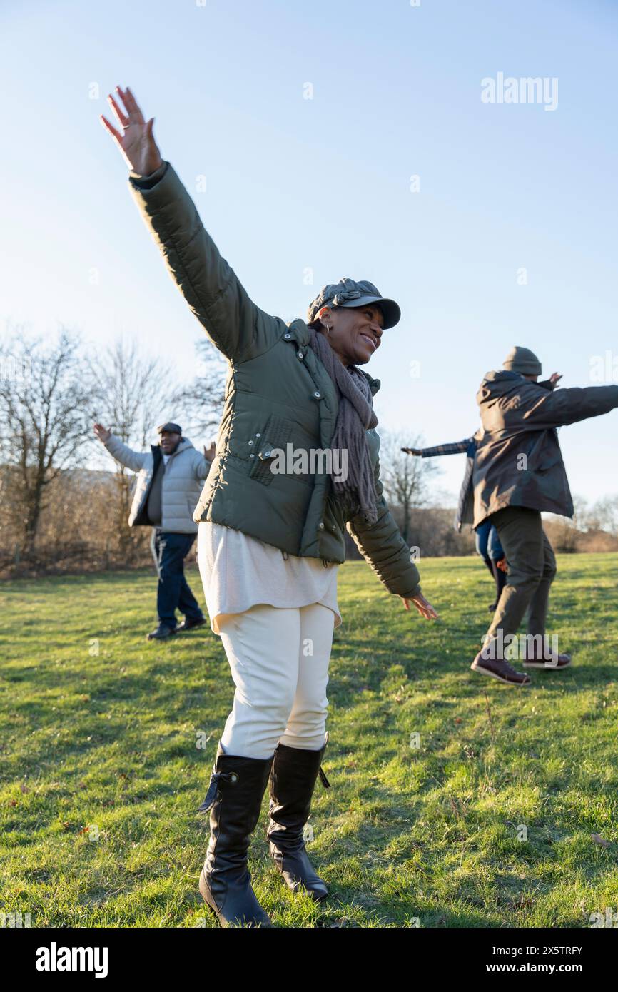 Persone con braccia allungate nel prato Foto Stock