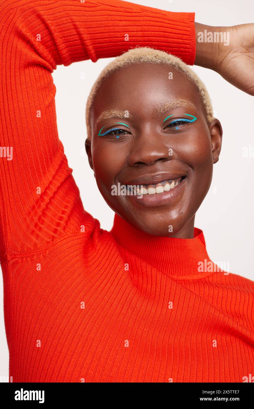 Donna sorridente con capelli bianchi corti, braccia sollevate Foto Stock