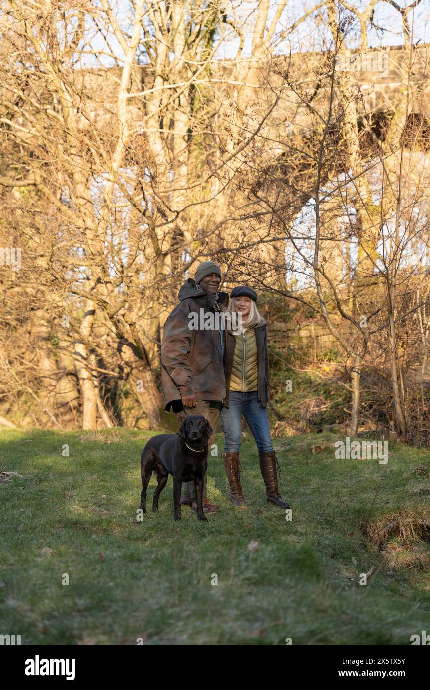 Coppia felice a piedi con il cane nel parco Foto Stock