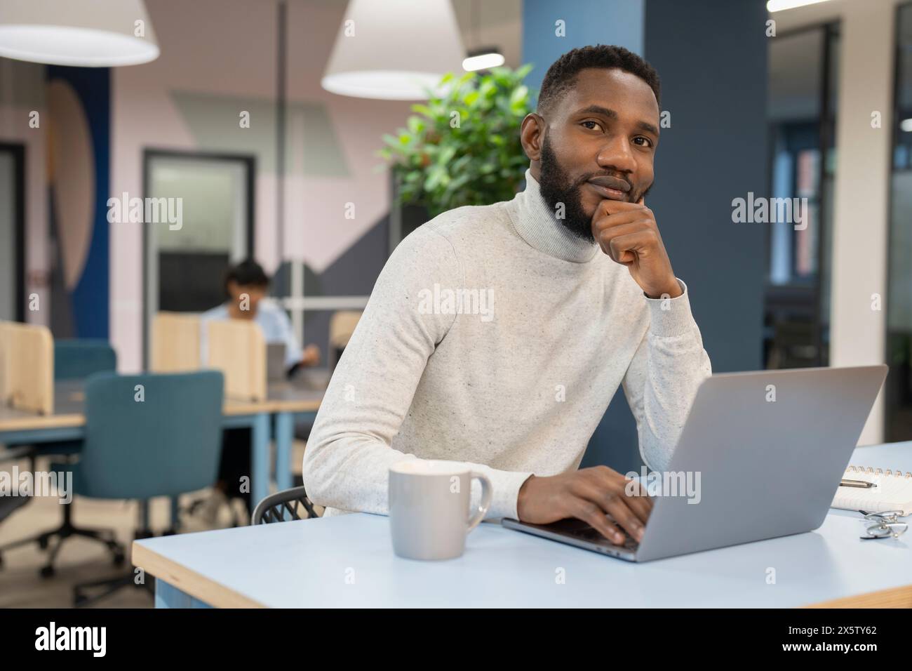 Giovane uomo che lavora sul computer portatile in ufficio Foto Stock