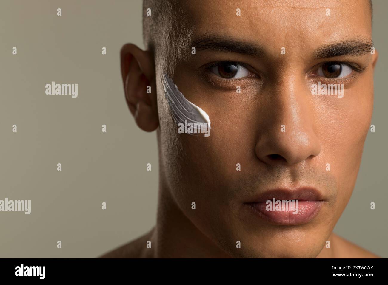 Primo piano di un uomo con crema per il viso sulla guancia Foto Stock