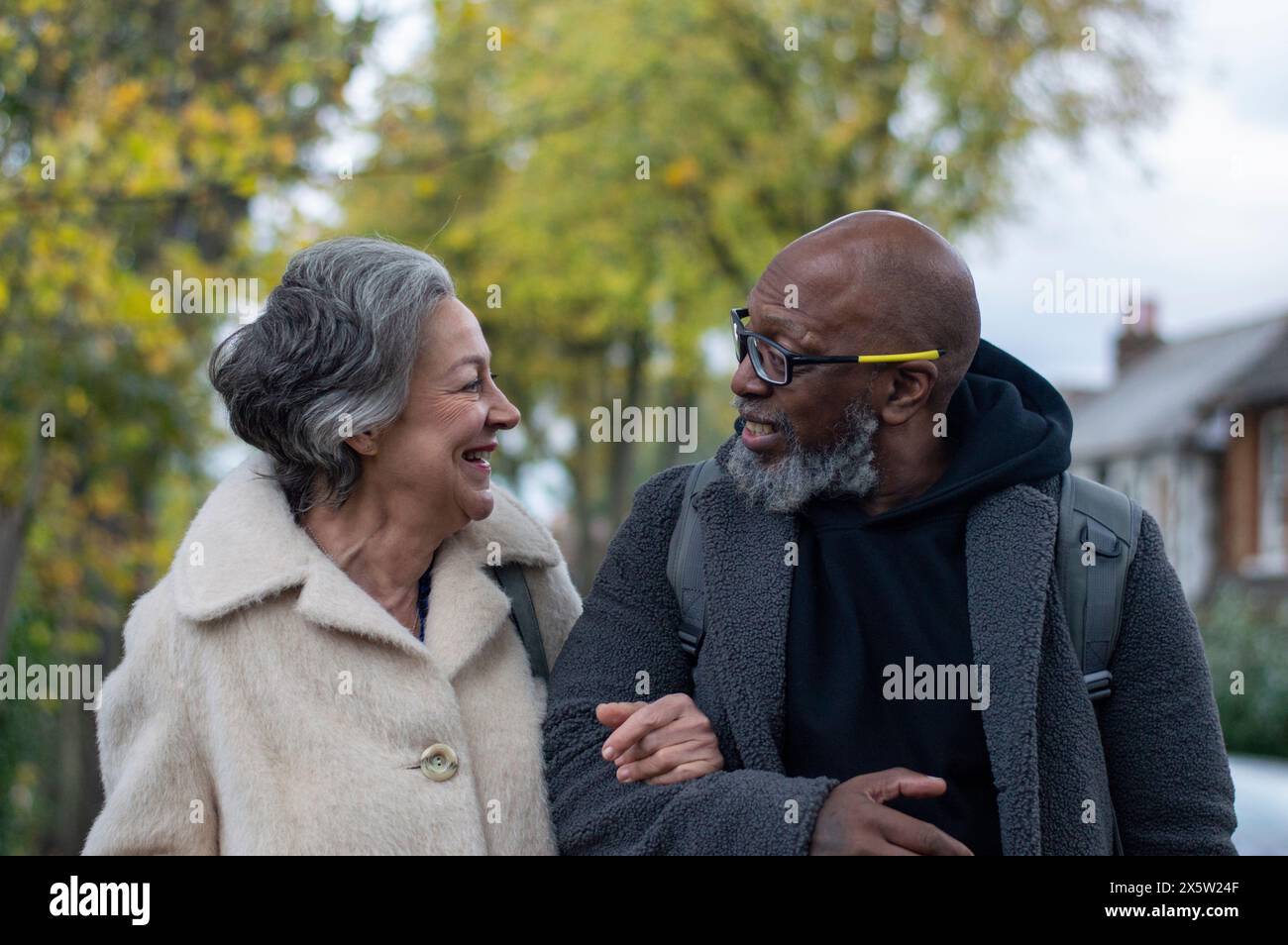 Coppia senior camminare a braccetto Foto Stock