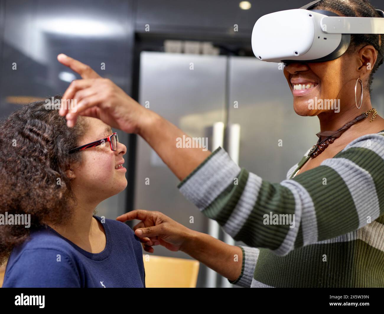 Ragazza con la sindrome di Down che guarda la madre con gli occhiali VR Foto Stock