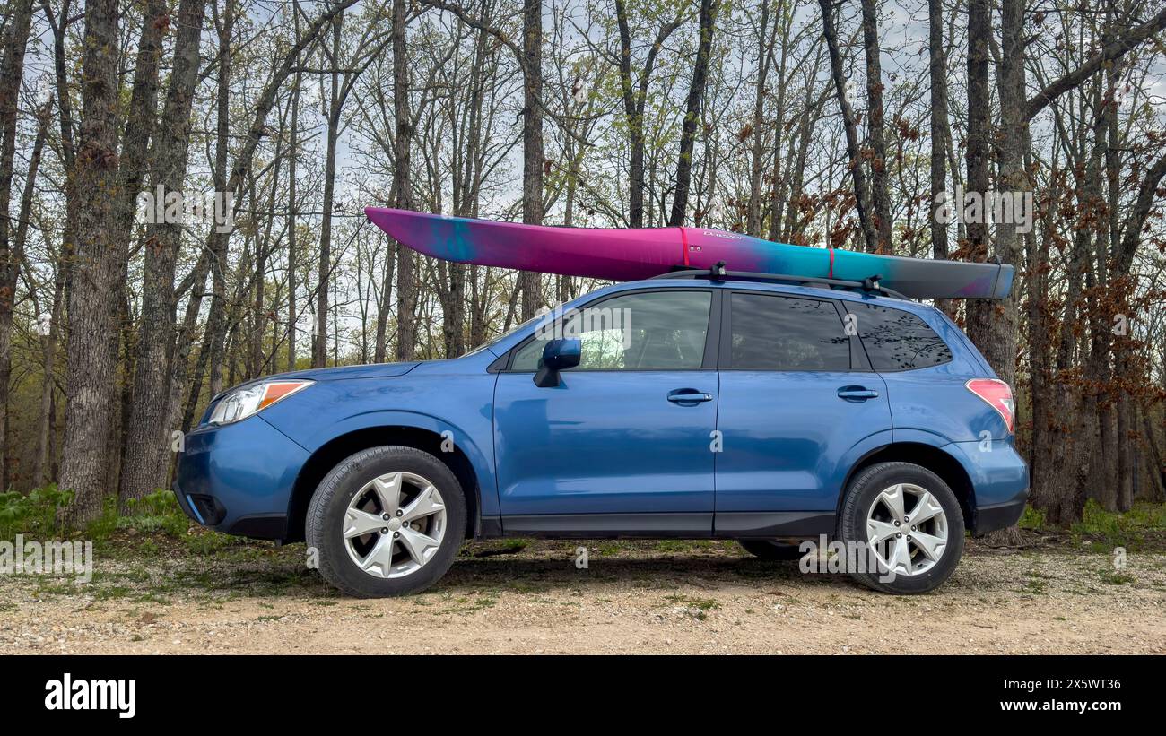 Rosebud, Missouri, Stati Uniti d'America - 20 aprile 2024: Kayak da pugnale sui portapacchi del SUV Subaru Forester in un parcheggio forestale. Foto Stock